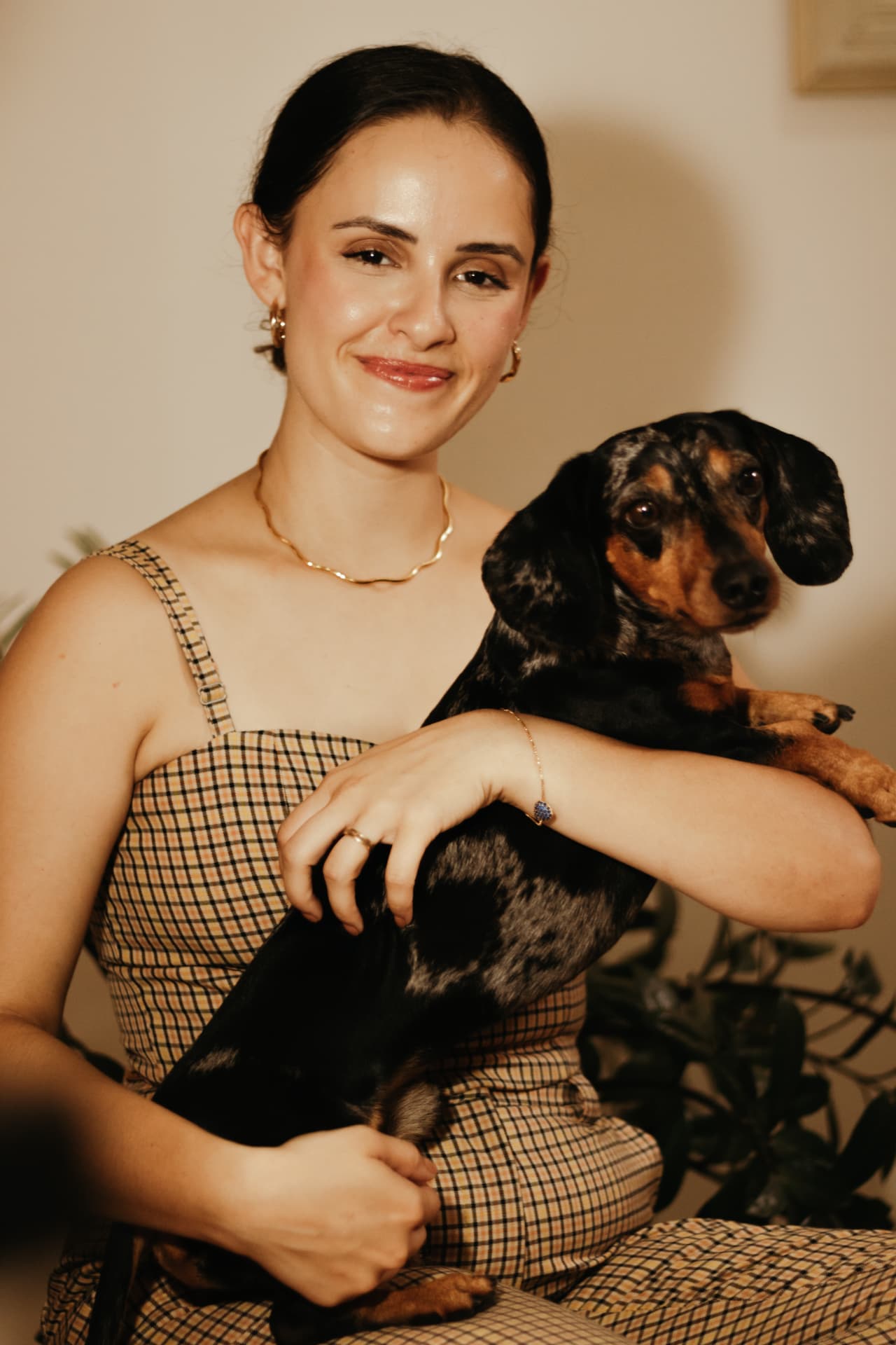 Carolina sorrindo enquanto segura seu cachorro no colo